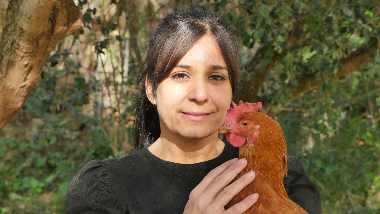 Marta Gallego sosteniendo con ternura a una gallina